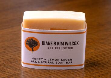 Honey + Lemon Lager All Natural Soap Bar on a wooden table.